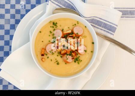 A sud la cucina tedesca, la zuppa di patate, crostini, stringa a fette di salsiccia, erba cipollina (Allium schoenoprasum), piastra, mestolo, Germania Foto Stock