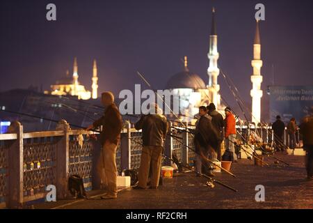 I pescatori del Ponte di Galata sopra il Golden Horn, due piani ponte stradale, traffico sopra, i bar e i ristoranti di seguito, Istanbul Foto Stock