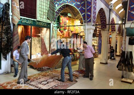 Rug merchant al Grand Bazaar o Bazaar coperto, Mercato coperto costituito da numerose volte con merci di tutti i tipi Foto Stock