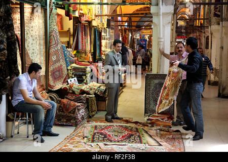 Rug merchant al Grand Bazaar o Bazaar coperto, Mercato coperto costituito da numerose volte con merci di tutti i tipi Foto Stock