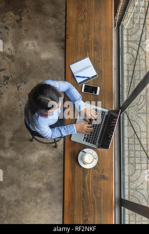 Vista superiore del giovane imprenditrice asiatici lavorando sul computer portatile Foto Stock