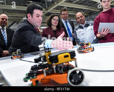 Zwickau, Germania. 23 gen 2019. Hubertus Heil (DOCUP, la seconda da sinistra) e federale, ministro del Lavoro e Andrea Nahles, presidentessa del DOCUP, informarsi circa la programmazione del robot del veicolo in corrispondenza di un supporto in stabilimento Volkswagen di Zwickau. I due uomini politici erano in Zwickau per colloqui riguardanti la trasformazione della pianta in un puro veicolo elettrico posizione. Con l'E-Auto ID, piani di Volkswagen per produrre il primo totalmente elettrico prodotto in serie auto da novembre 2019. Credito: Hendrik Schmidt/dpa-Zentralbild/dpa/Alamy Live News Foto Stock