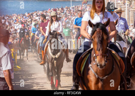 Cavalli e Cavalieri lasciando La Enramada beach dopo la balneazione i loro animali in mare a San Sebastian romeria, fieasta, La Caleta, Tenerife, può Foto Stock