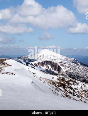 Vista delle colline pietrose con la neve e il blu del cielo. Molla di drammatica scena. Fotografia di paesaggi Foto Stock