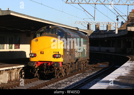 Classe 37 diesel-elettrico in loco direttamente i servizi ferroviari livrea nella luce di lavoro del motore che passa attraverso la stazione di Carnforth piattaforma 2 il 23 gennaio 2019. Foto Stock