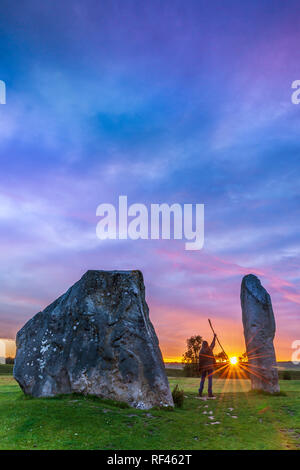 Una immagine di un druido salutare il sole, tra il gigante Sarsen Pietre di Avebury nel Wiltshire, il giorno prima del solstizio. Immagine acquisita utilizzando un Ni Foto Stock