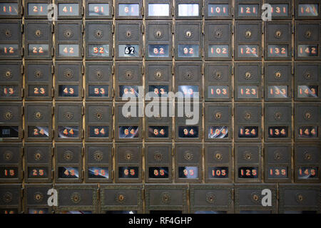 Caselle postali e un ufficio postale che utilizza una chiave per sbloccare le caselle postali. Foto Stock