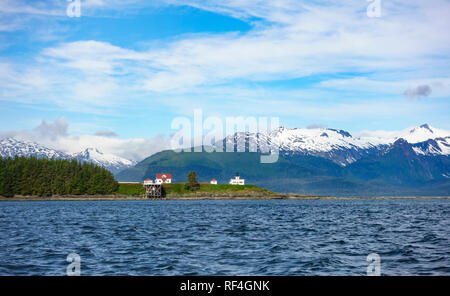 Punto storico faro di ritiro, Admiralty Island, Juneau in Alaska, con montagne innevate sullo sfondo Foto Stock