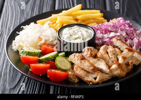 Pollo mediterraneo Shawarma ciotola con le patatine fritte, verdure e salsa di close-up su una tavola di legno orizzontale. Foto Stock