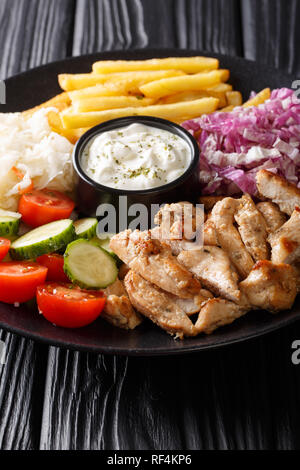 Shawarma ciotola con pollo e verdure e salsa di close-up su una tavola di legno verticale. Foto Stock