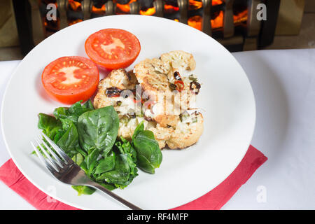 Cavolfiore arrosto di manzo servita con Spinaci appassito e pomodoro grigliate Foto Stock