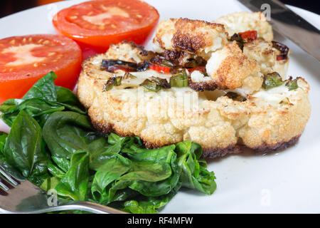 Cavolfiore arrosto di manzo servita con Spinaci appassito e pomodoro grigliate Foto Stock