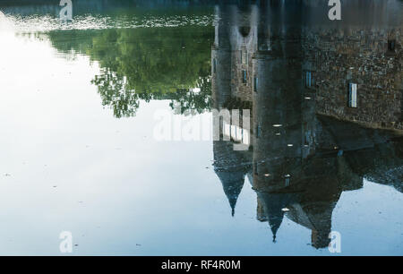 Riflesso nello stagno delle torrette del XIV secolo Chateau de Trecesson Foto Stock