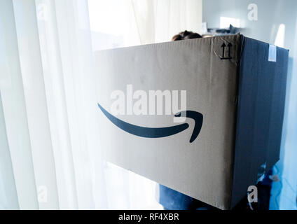 Parigi, Francia - Dic 25, 2018: dai toni blu immagine di donna tenere grandi Amazon parcel scatola di cartone sul giorno di Natale con grande enorme dono all'interno Foto Stock