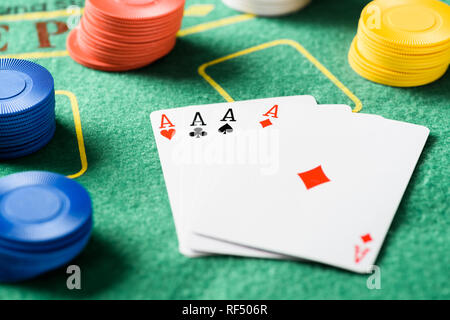 Messa a fuoco selettiva di verde tavolo del poker con quattro assi giocando a carte e trucioli Foto Stock