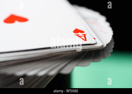 Messa a fuoco selettiva di ace carta da gioco con cuori muta in mazzo su sfondo verde Foto Stock