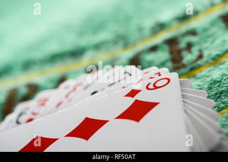 Messa a fuoco selettiva di carta da gioco con diamanti muta in mazzo sul tavolo verde Foto Stock
