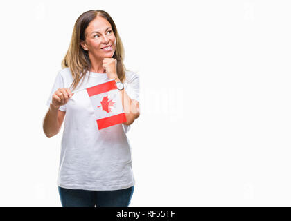 Medioevo donna ispanica holding bandiera del Canada su sfondo isolato faccia seriamente pensando di domanda, molto confusa idea Foto Stock