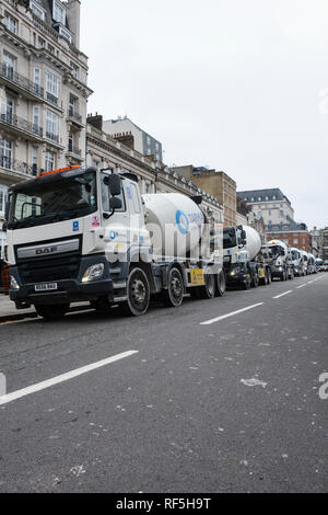 Una coda di Tarmac DAF Trucks attendere per scaricare il loro calcestruzzo preconfezionato delle basi della LSE dell edificio Marshall in Lincoln' s Inn campi, Londra Foto Stock