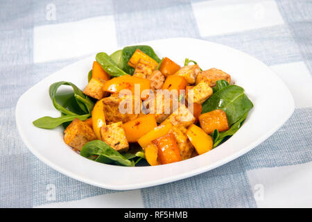 Il tofu in agrodolce con peperoni su letto di spinaci Foto Stock