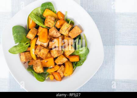 Il tofu in agrodolce con peperoni su letto di spinaci Foto Stock