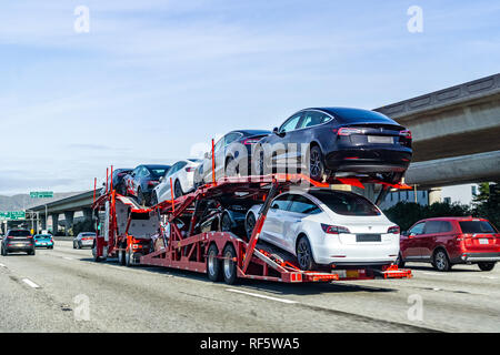 Gennaio 19, 2019 San Bruno / CA / STATI UNITI D'AMERICA - Car transporter porta Tesla Modello 3 nuovi veicoli lungo l'autostrada a San Francisco Bay Area, vista posteriore di t Foto Stock