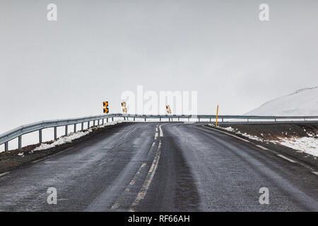 Attraverso il parabrezza colpo di una strada asfaltata in Oriente in Islanda in presenza di nebbia. Foto Stock