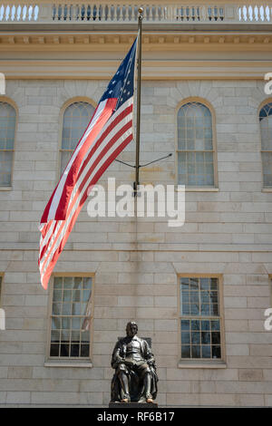 John Harvard statua wit ha grande sventolio della bandiera americana in background e la Harvard University di Cambridge, Massachusetts, STATI UNITI D'AMERICA Foto Stock