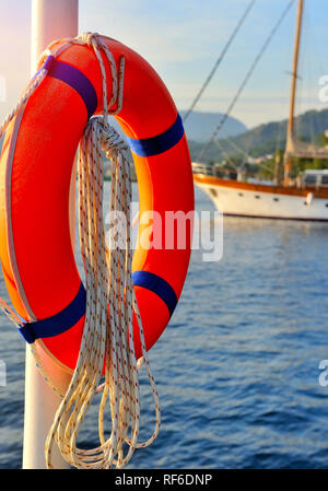 Ciambella arancione con lo sfondo del mare e le barche Foto Stock