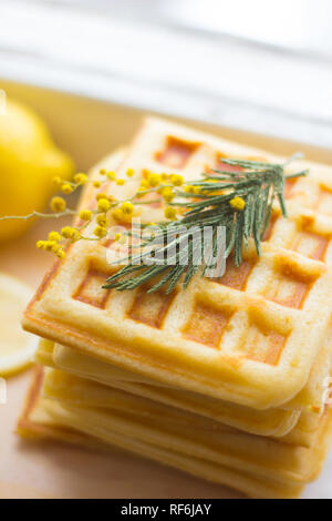 Wafer Viennese pila e fette di limone. Fette di limone su una tavola di legno. I frutti vengono tritati. Sour limone. Gli agrumi Foto Stock