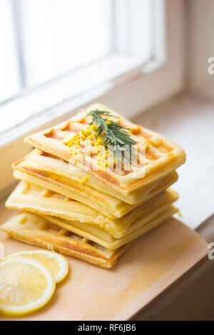 Wafer Viennese pila e fette di limone. Fette di limone su una tavola di legno. I frutti vengono tritati. Sour limone. Gli agrumi Foto Stock