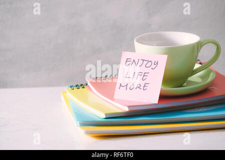 Tazza verde con adesivo e il notebook sul piano portapaziente. Foto Stock