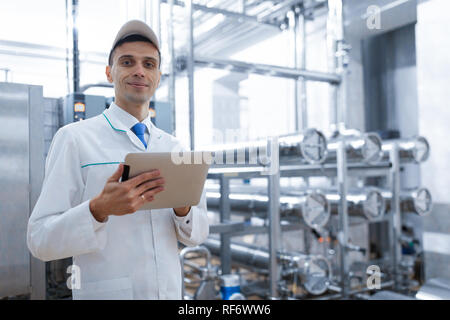 Il Tecnologo con una compressa nelle sue mani presso il caseificio Foto Stock