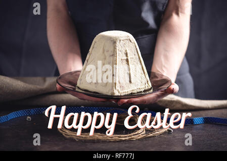 Una scheda con la tradizionale torta di Pasqua e uova colorate e il testo in stile rustico. felice Pasqua Foto Stock