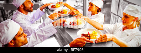 Chef passando il cibo pronto al cameriere a stazione di ordine Foto Stock