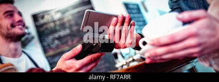 Il cliente con il cellulare in piedi con la barista presso il cafe Foto Stock