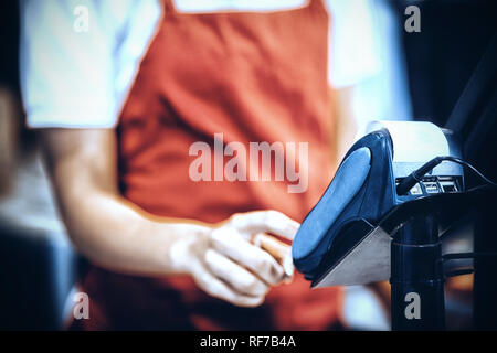 Personale femminile utilizzando la carta di credito terminale al contatore di cassa Foto Stock