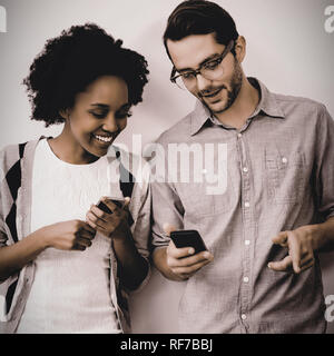 Uomo e donna che utilizza il telefono cellulare Foto Stock