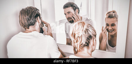 Giovane controllando la loro pelle in bagno Foto Stock