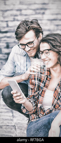 Coppia giovane utilizzando il telefono cellulare Foto Stock