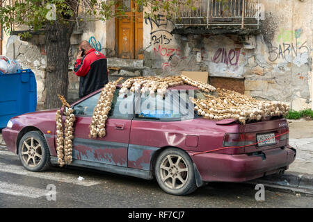 L'uomo vendita di aglio alla strada del mercato di Kalamata, MESSINIA, PELOPONNESO Meridionale, Grecia. Foto Stock
