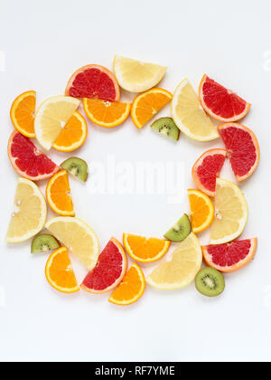 Creative Circle disposizione delle fette di frutta - kiwi, arance e pompelmi. Lay piatto con spazio di copia Foto Stock