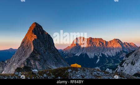 Vertice dell'Sonnenspitze e tenda con Zugspitze nel fondo alla luce della sera, Ehrwald, Außerfern, Tirolo, Austria Foto Stock