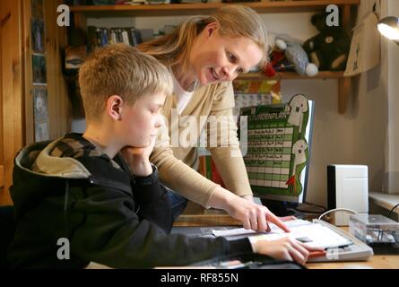 DEU, Germania: Madre sta aiutando il suo figlio con i compiti di scuola. Foto Stock