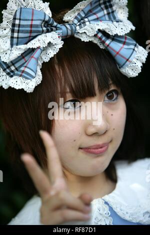 Ragazza con un fiocco tra i capelli, vittoria, Yoyogi Park Harajuku, Tokyo, Giappone, Asia Foto Stock