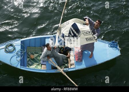 Fornitori su imbarcazioni a remi cercando di vendere souvenir per i passeggeri di una nave da crociera sul Nilo mentre è in attesa presso il fiume bloccare Foto Stock