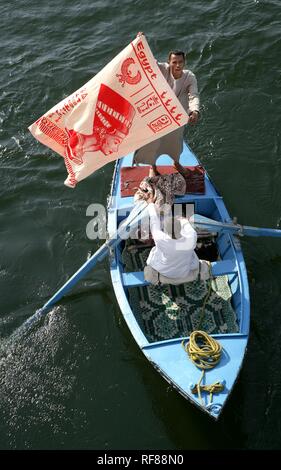 Fornitori su imbarcazioni a remi cercando di vendere souvenir per i passeggeri di una nave da crociera sul Nilo mentre è in attesa presso il fiume bloccare Foto Stock