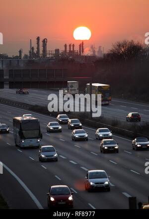 A3 Autobahn (autostrada) Oberhausen-Holten vicino al tramonto, OXEA Ruhrchemie impianto chimico in background, Oberhausen Foto Stock