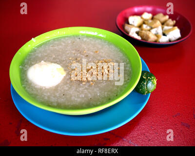 Foto di cucinata fresca farinata di riso con uovo e interiora di maiale noto comunemente nelle Filippine come Goto o Lugaw con tofu fritto sidedish Foto Stock