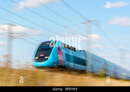 Un treno TGV Duplex ad alta velocità a Ouigo livrea della società francese SNCF che guida a piena velocità sulla ferrovia ad alta velocità dell'Europa orientale (motion blur). Foto Stock